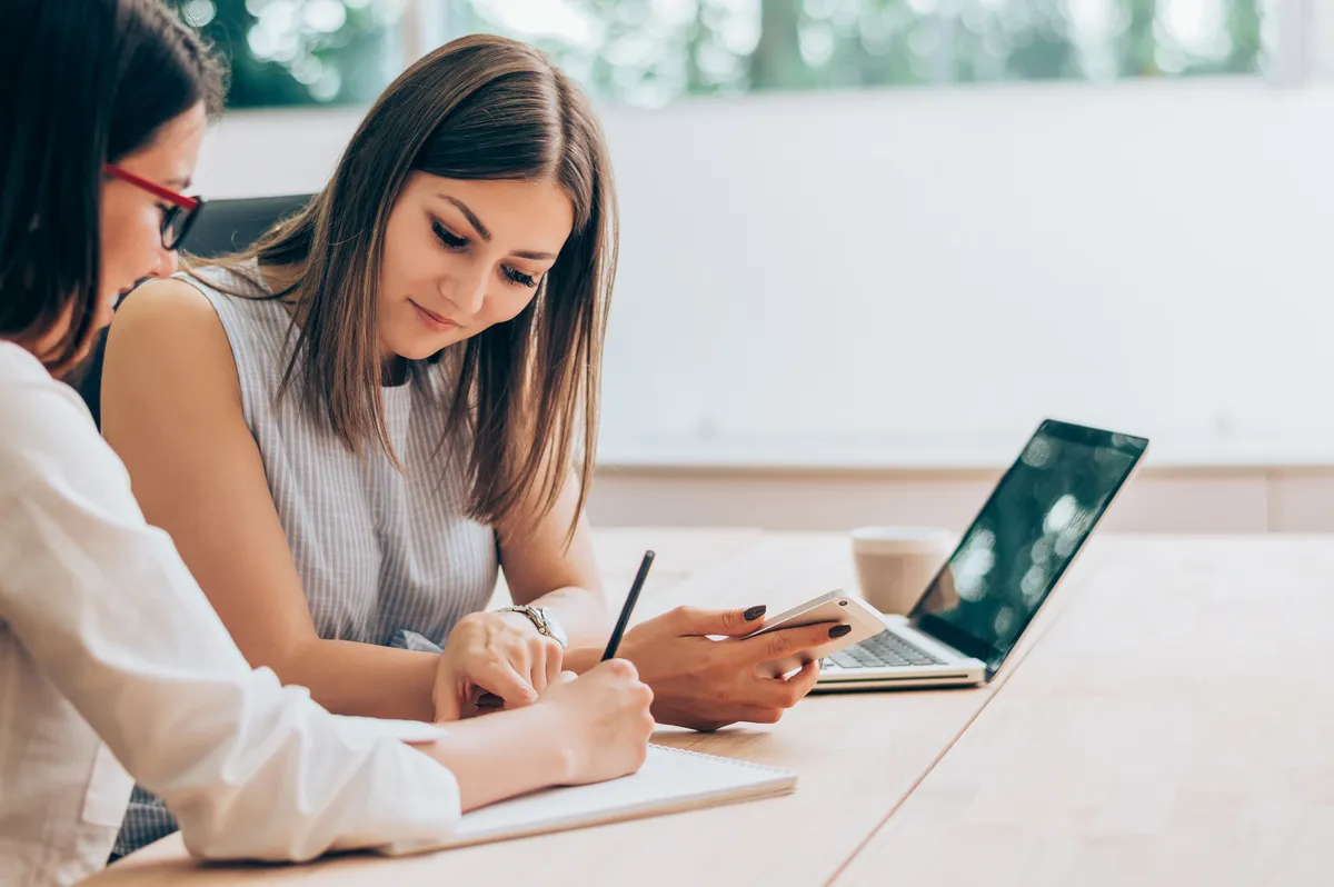 zwei Frauen diskutieren und arbeiten am Laptop