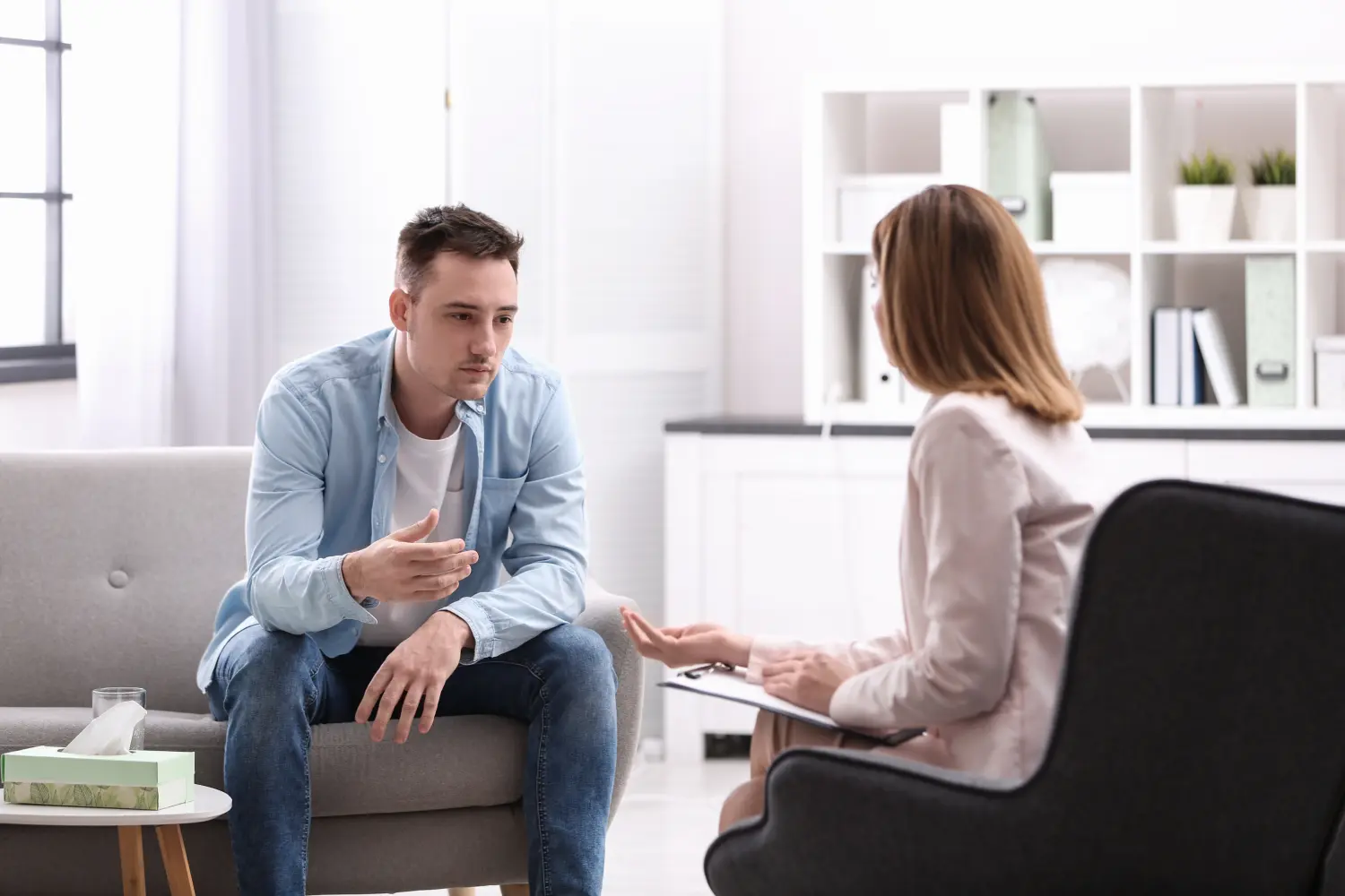 Seitenansicht eines professionellen Psychologen, der mit einem Patienten aus dem Nahen Osten arbeitet, der an einer schweren depressiven Störung leidet